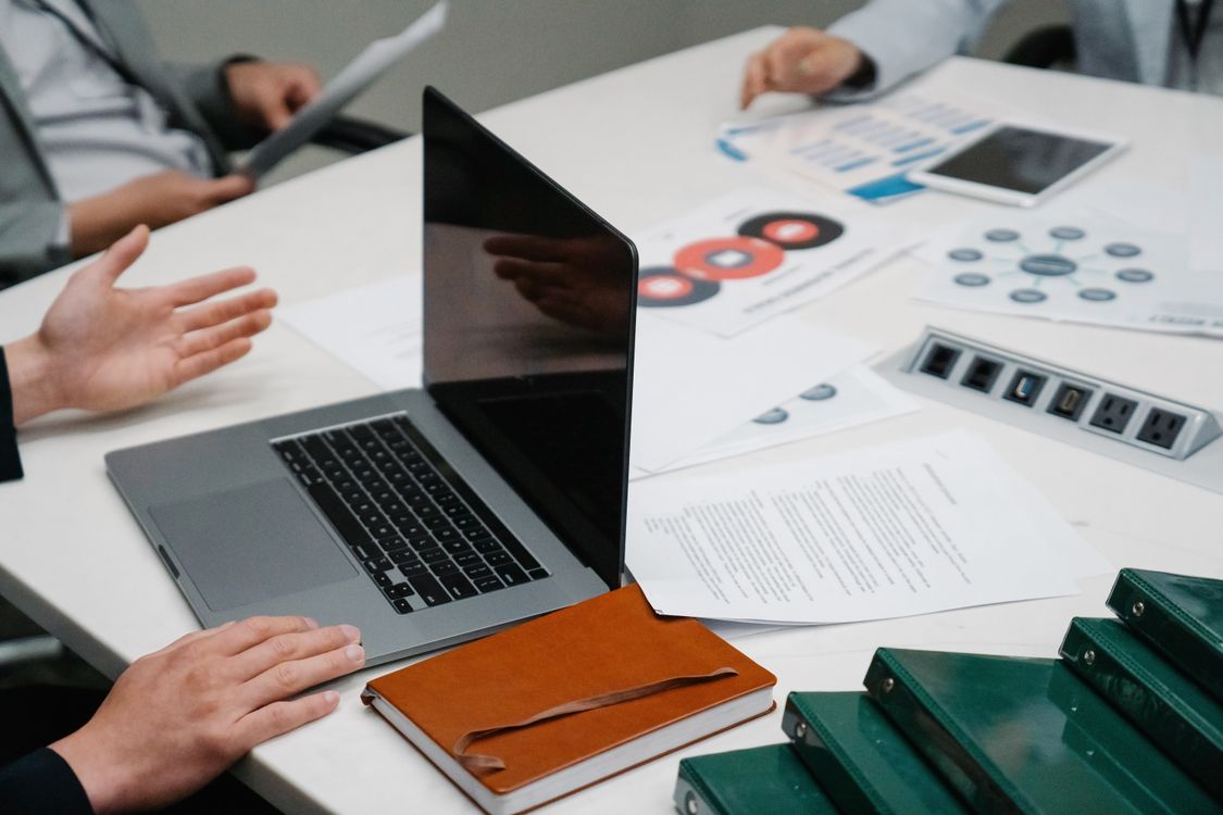 Mesa com computador, documentos e materiais de planeamento